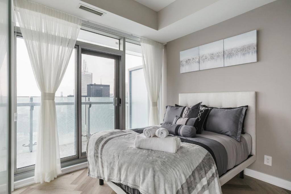 a bedroom with a bed and a large window at The One - Make Memories! - Urban City - Boutique in Toronto