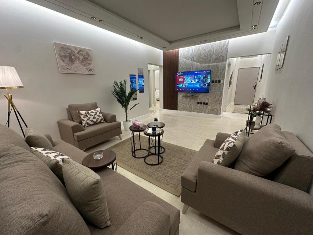 uma sala de estar com dois sofás e uma televisão em شقة فاخرة غرفتين نوم ودخول ذاتي em Riyadh