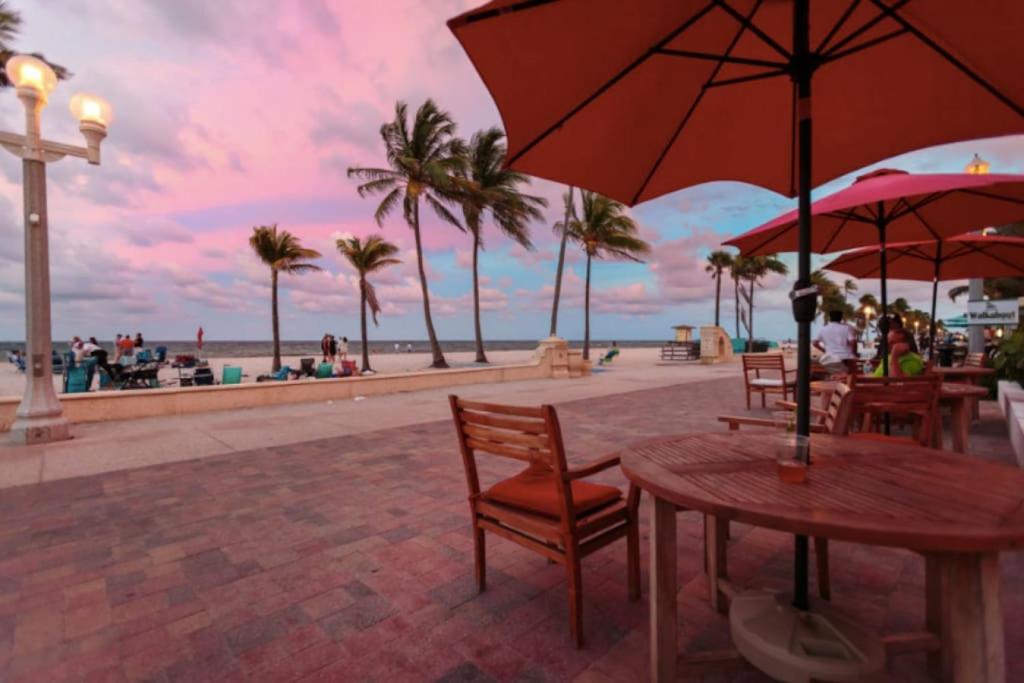 a table with chairs and an umbrella on the beach at Walkabout 8 Tower Suite with Panoramic Ocean Views in Hollywood