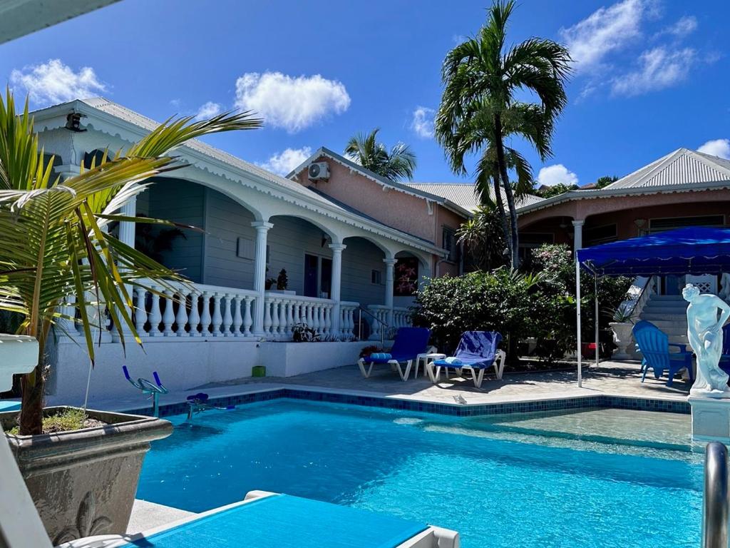 a house with a swimming pool in front of a house at Sun Caraibes in Orient Bay