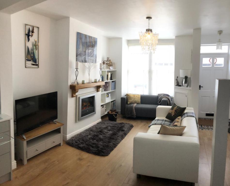 a living room with a couch and a television at Downtown Cottage Conwy in Conwy