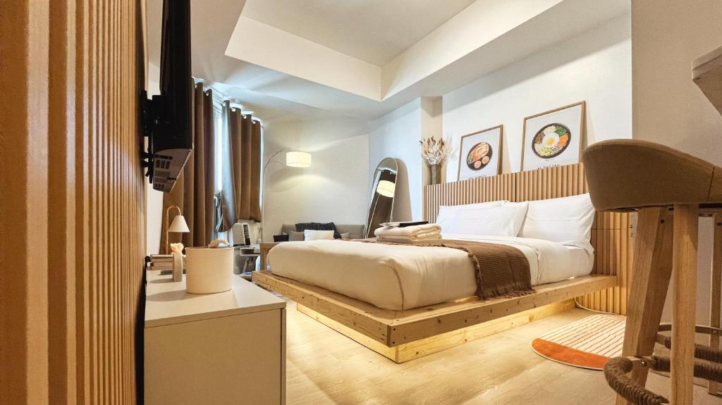 1 dormitorio con 1 cama en una plataforma de madera en Cozy Kkum - Korean Inspired Staycation at Azure North, en Lagundi