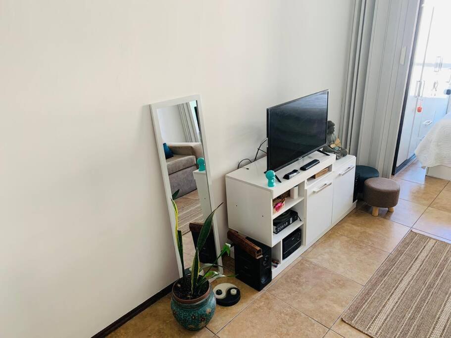 un salon avec une télévision à écran plat sur une armoire blanche dans l'établissement Apartamento hermoso cómodo en la mejor zona, à Montevideo