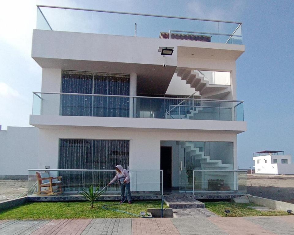 une personne debout devant un bâtiment dans l'établissement APARTAMENTOS CON PISCINA Y ACCESO A PLAYA, à Cerro Azul