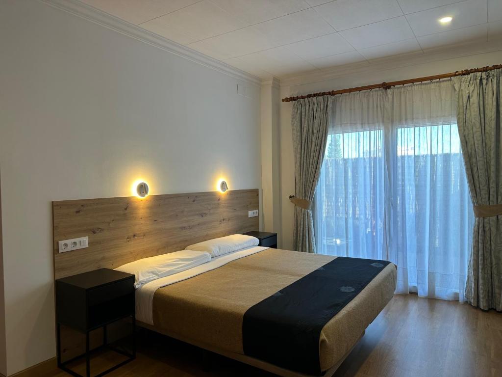 a bedroom with a large bed and a large window at La Luna Blanca in Torremolinos