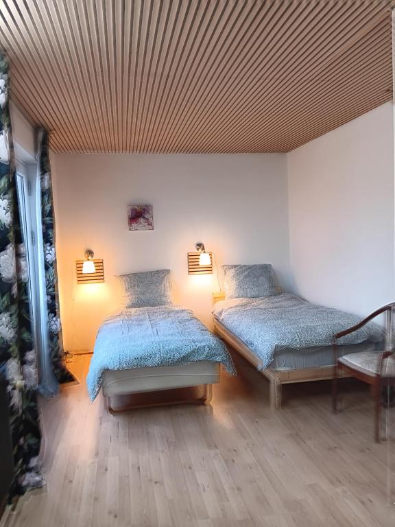 um quarto com 2 camas e um tecto com luzes em Private room near Copenhagen em Ishoj
