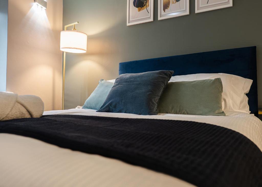 a bedroom with a bed with a blue headboard and pillows at Windsor Court in Brighton & Hove