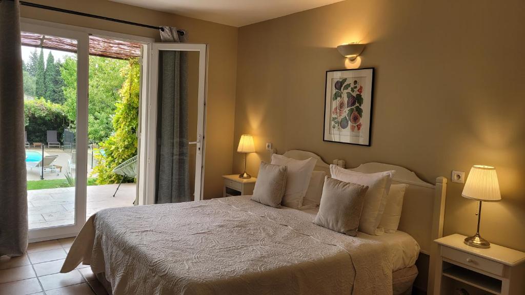 a bedroom with a bed and a sliding glass door at Mas des Marguerites in Maussane-les-Alpilles