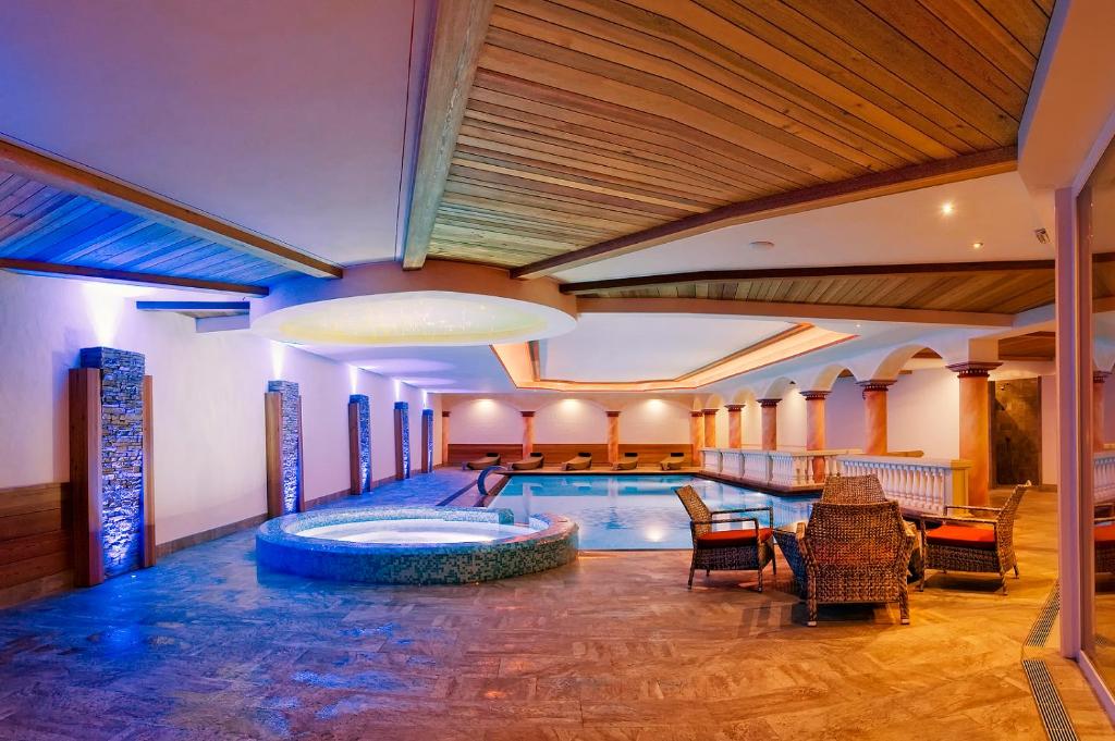 uma piscina num hotel com cadeiras e uma mesa em Park Hotel Bellavista em Calalzo