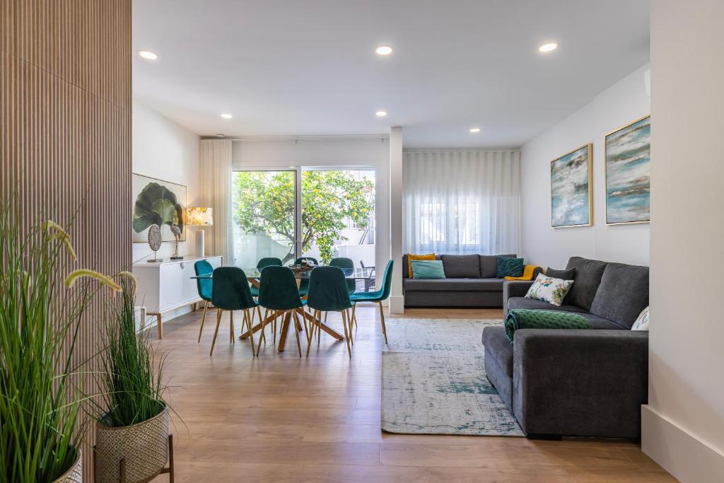 sala de estar con sofá, mesa y sillas en Apartamento Moderno com Terraço en Lisboa