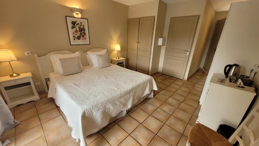 a bedroom with a white bed and two lamps at Mas des Marguerites in Maussane-les-Alpilles
