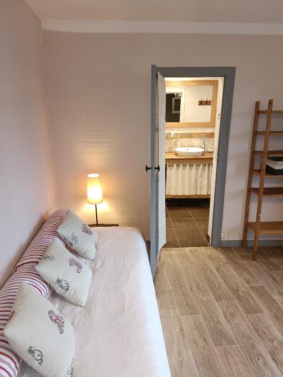 a bedroom with a bed with pillows and a bathroom at Lovely cottage in Honfleur center in Honfleur