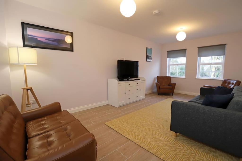 uma sala de estar com um sofá e uma televisão em Royal Hillsborough Village Luxury Townhouse em Hillsborough