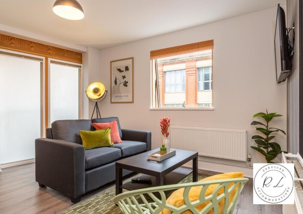 sala de estar con sofá y mesa en Modern Spacious Apartment in Leicester City Centre with Free Parking!, en Leicester