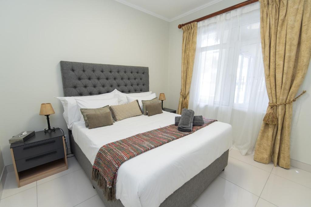 a bedroom with a large bed and a window at Hallack Du Parc Modern Living in Port Elizabeth