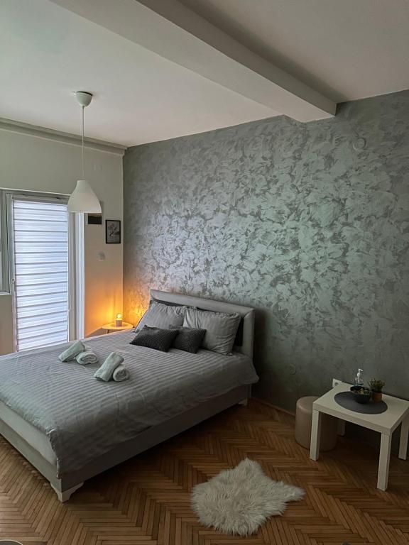 a bedroom with a bed and a wall with flowers at Loli apartman in Kraljevo