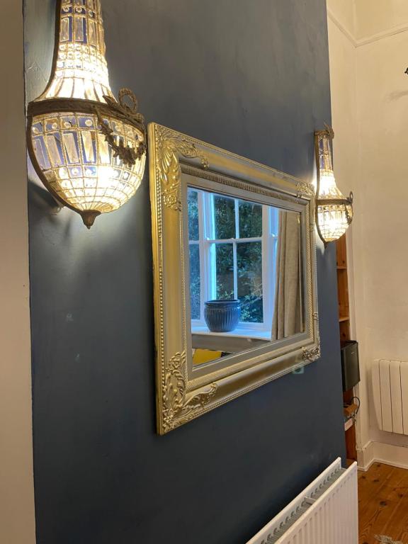 einen Spiegel an einer Wand mit einem Fenster und Lichtern in der Unterkunft Ledville Castle in Dublin