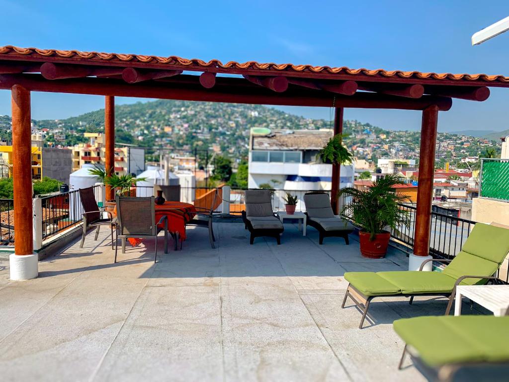 a patio with chairs and a table on a roof at Hotel Valle in Zihuatanejo