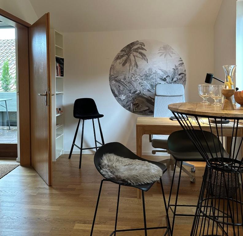 a dining room with a table and two stools at Dachstudio Apartment in Ulm in Ulm
