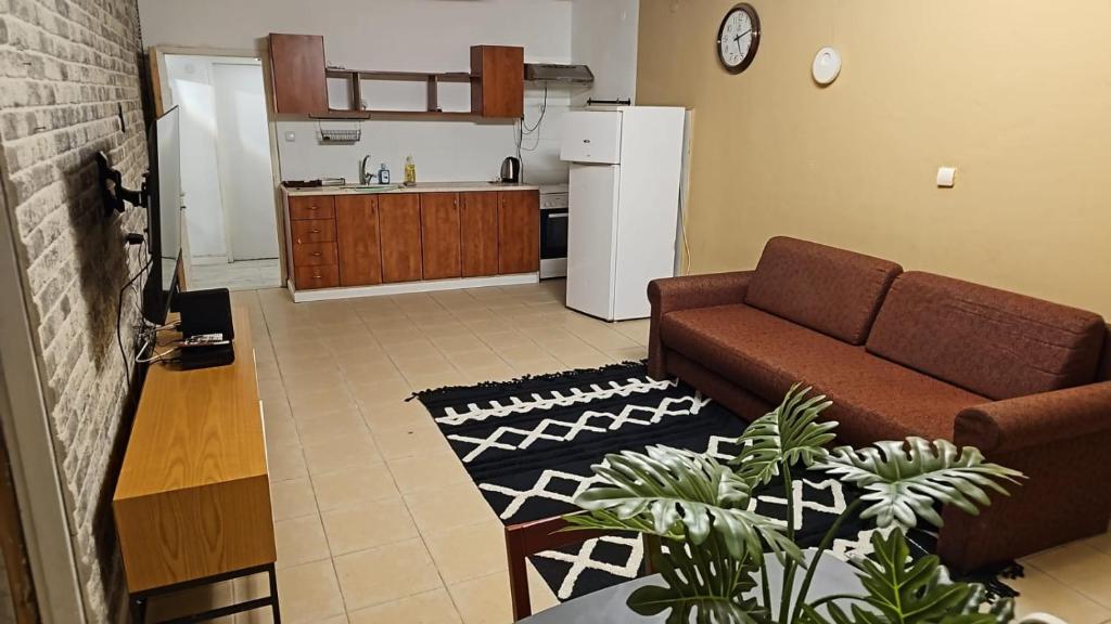 a living room with a couch and a kitchen at Happy Home in Eilat