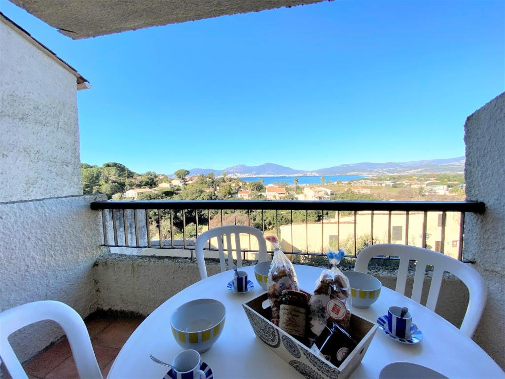 une table blanche et des chaises sur un balcon dans l'établissement Appartement 8 Terra Bella 1 Porticcio, à Porticcio