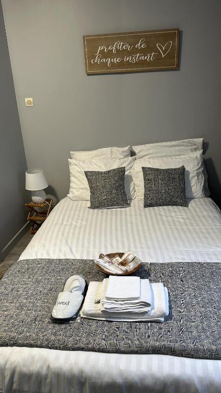 a bed with a tray of towels and shoes on it at Location saisonnière Angoulême in Angoulême