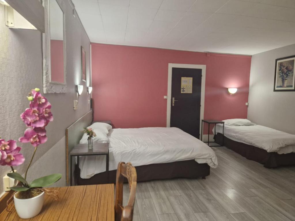 una habitación de hotel con 2 camas y una mesa con sidra de mesa en Hotel de l'Academie, en Nancy