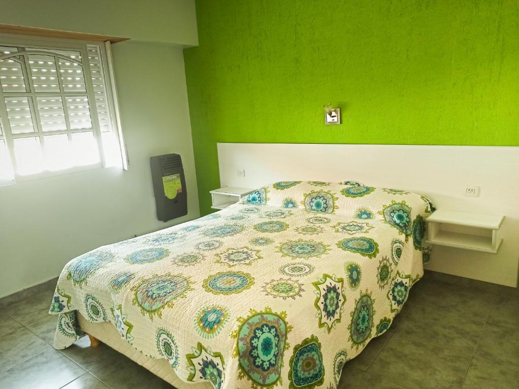 a bedroom with a bed with a floral bedspread at Alquileres Relax11sanclemente in San Clemente del Tuyú