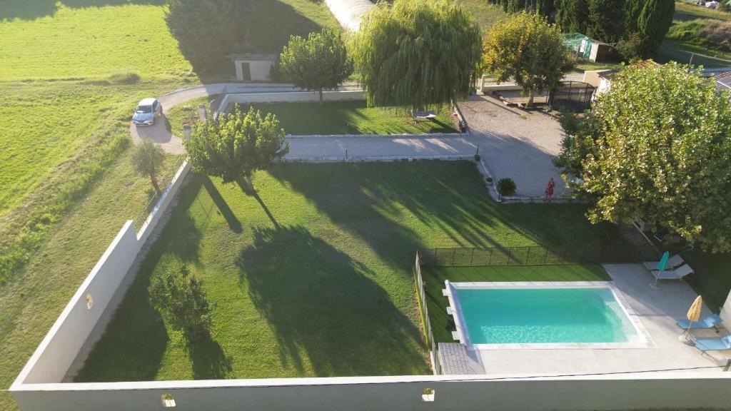 - une vue sur une grande cour avec une piscine dans l'établissement Le Petit Mas Rey, à Eyragues