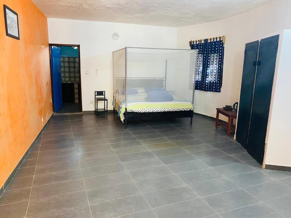 een slaapkamer met een bed en een tegelvloer bij Lodge des marseillais in Ouoran