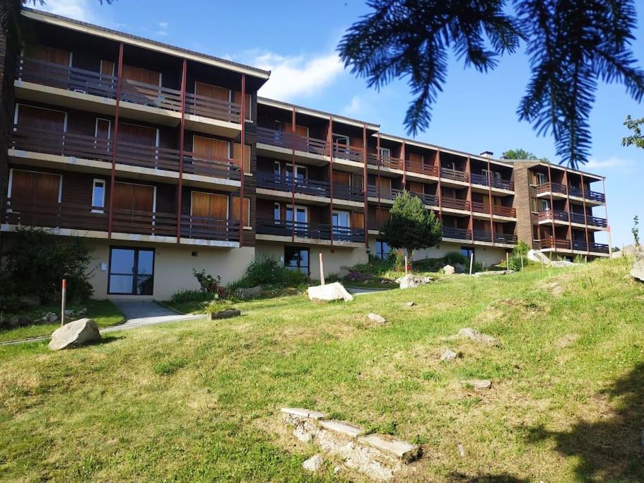un grand bâtiment avec une pelouse devant lui dans l'établissement Appartement confort lumineux, terrasse avec vue, à Font-Romeu-Odeillo-Via