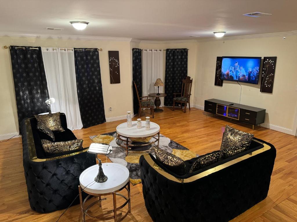 sala de estar con 2 sofás y TV de pantalla plana en Affordable Luxury Home Near NYC & EWR, en Newark