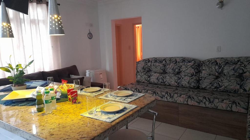 una sala de estar con una mesa y un sofá en Apartamento em Ubatuba- centro - apartamento 2 quartos com ar cond, en Ubatuba