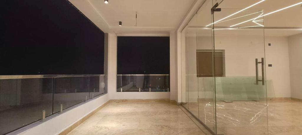 Una ducha de cristal en una habitación con ventana en Nebo Suites, en Visakhapatnam