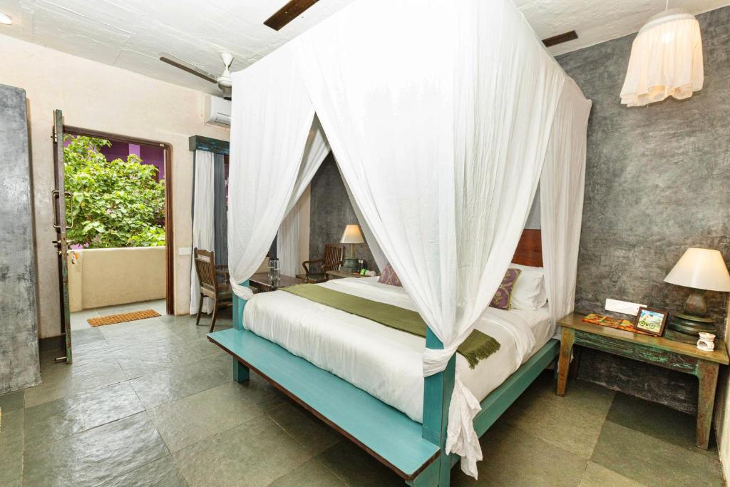 a bedroom with a bed with a canopy at GERANIUM HAVEN in Arambol