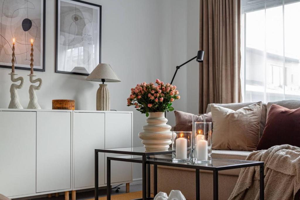 ein Wohnzimmer mit einem Sofa und einem Tisch mit Blumen darauf in der Unterkunft Simple studio in trendy Södermalm - construction work in Stockholm