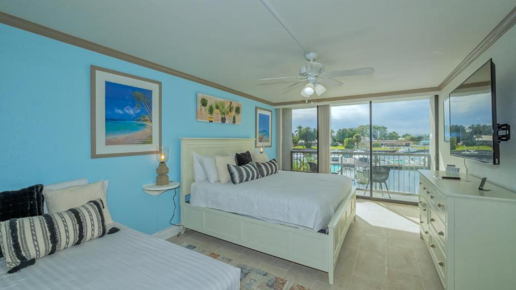 um quarto azul com 2 camas e uma varanda em ALL-NEW Waterfront with Balcony,Pool,Tiki Bar,Gym em Sarasota