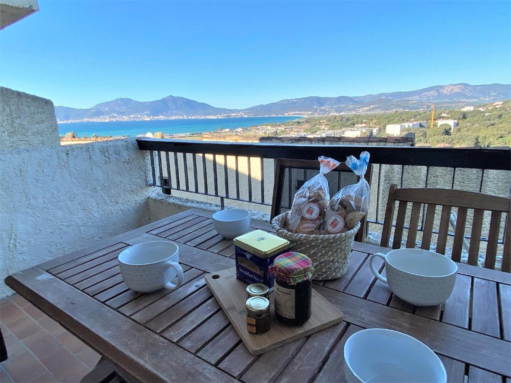 - une table de pique-nique avec un panier de nourriture sur le balcon dans l'établissement Appartement 86 Terra Bella 1 Porticcio, à Porticcio