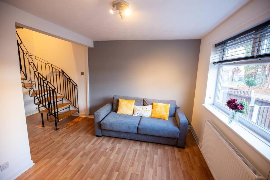 sala de estar con sofá azul y ventana en Entire 1 Bedroom House in Manchester en Mánchester