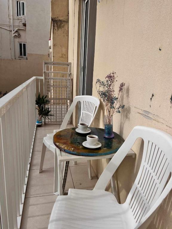 d'une table et de deux chaises sur un balcon. dans l'établissement Lovely Home, à Il-Gżira