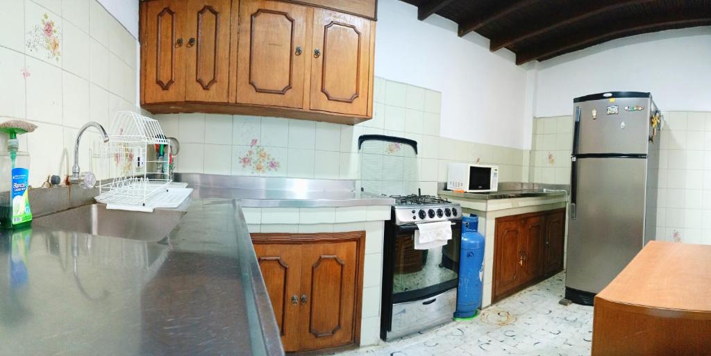 a kitchen with wooden cabinets and a stainless steel appliance at Espacio seguro, amplio y acogedor in Medellín