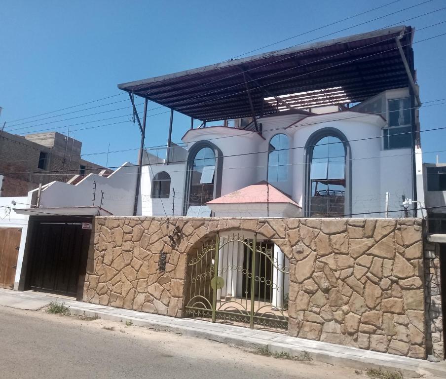 um edifício com uma parede de pedra com um portão em Recreo Beach em Huanchaco