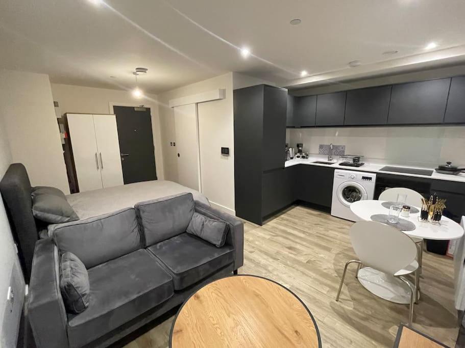 a living room with a couch and a kitchen at Stylish flat in Old Trafford in Manchester