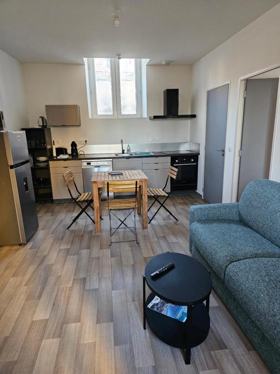 茅爾斯的住宿－Logement centre ville，带沙发和桌子的客厅以及厨房。