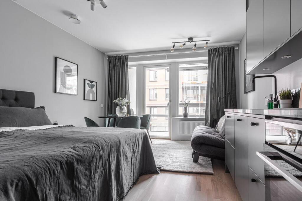 ein Schlafzimmer mit einem Bett und eine Küche mit einem Fenster in der Unterkunft Beautiful and cozy Studio in a New building in Stockholm