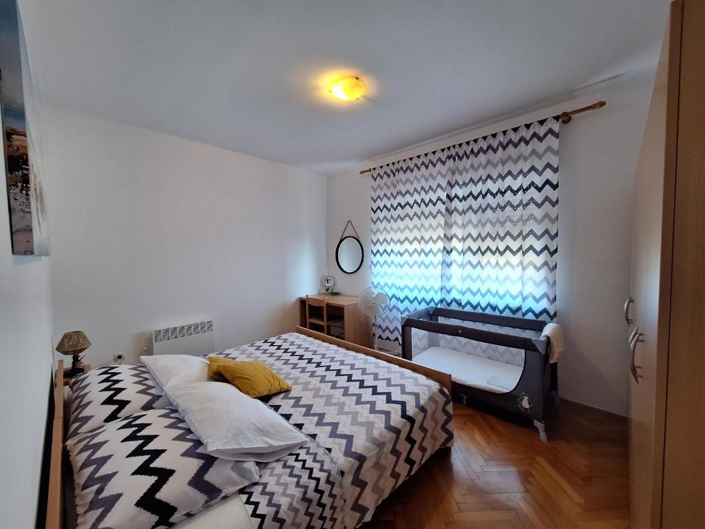 een kleine slaapkamer met een bed en een raam bij Apartmani Marini in Opatija