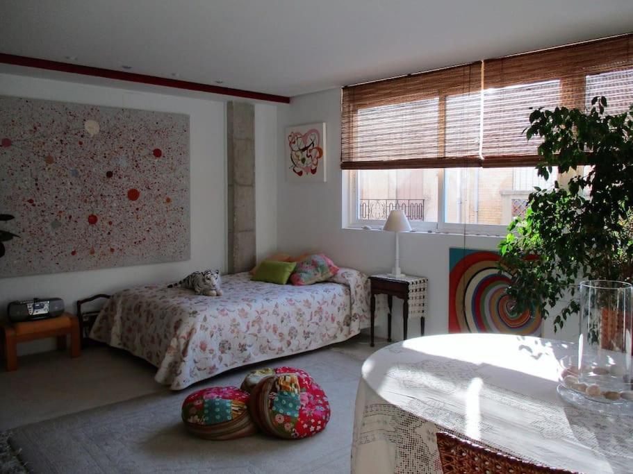 a bedroom with a bed and a table and a window at Artistic and spacious loft in a little town near the sea and the city in Sedaví