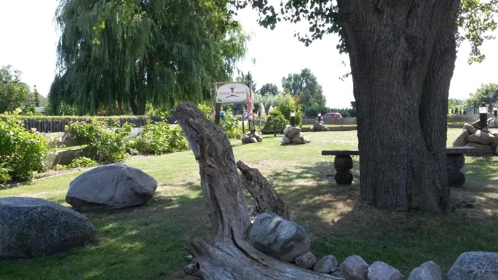 ein Baum und ein Park mit Steinen und einer Bank in der Unterkunft Ostseekojen in Peenemünde