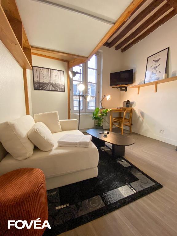 un salon avec un canapé blanc et une table dans l'établissement Arés, à Caen