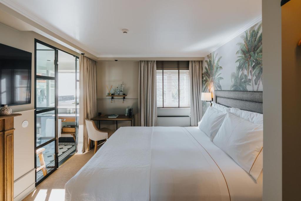 a bedroom with a large white bed and a desk at AlmaLusa Alfama in Lisbon